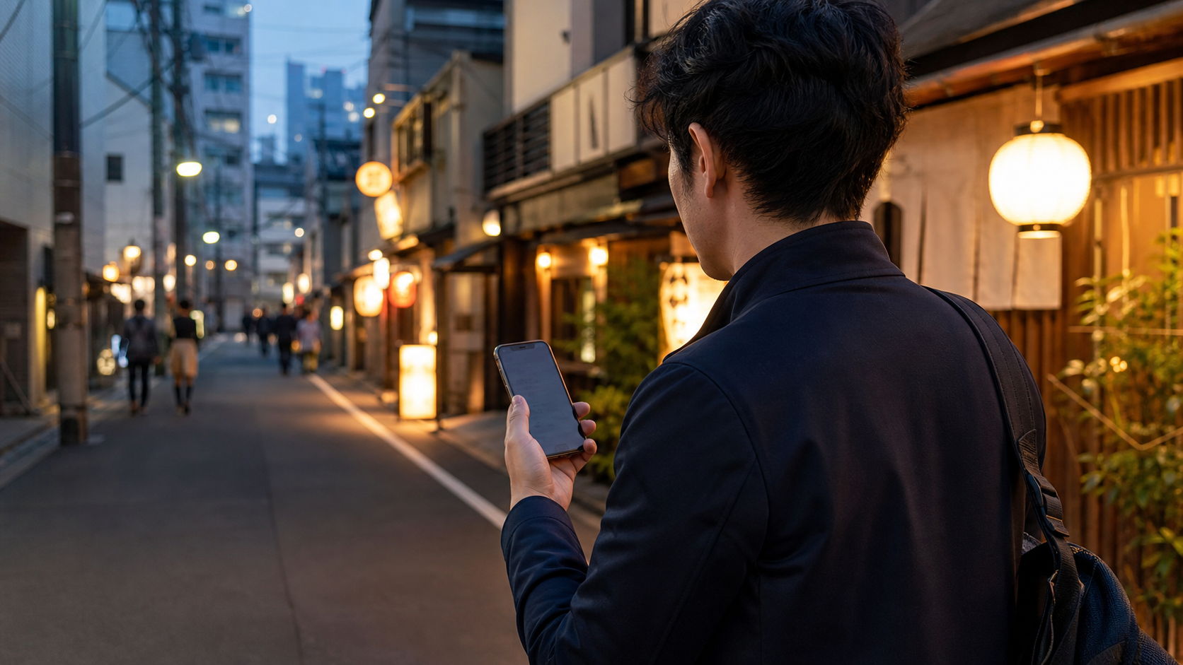 Traveller using mobile maps on a Tokyo side street at blue hour